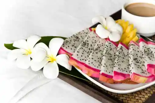 cut dragot fruit pieces decorated on a plate with flowers